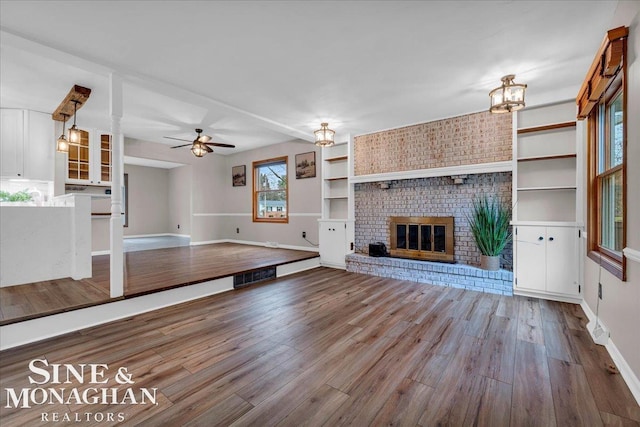 unfurnished living room with hardwood / wood-style floors, ceiling fan, and a fireplace