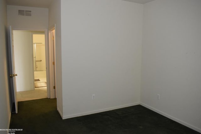 unfurnished room with dark colored carpet