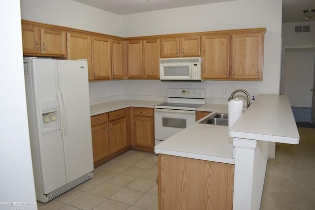 kitchen with sink, white appliances, kitchen peninsula, and light tile patterned flooring