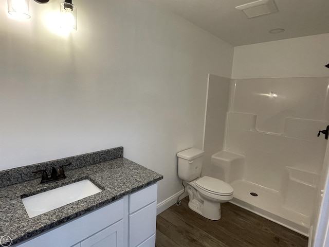 bathroom with walk in shower, toilet, vanity, and hardwood / wood-style flooring