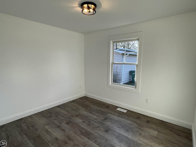 unfurnished room with dark wood-type flooring