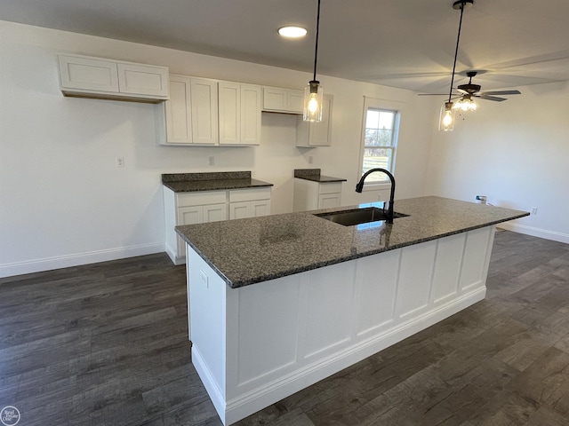 kitchen with white cabinetry, a center island with sink, ceiling fan, and sink