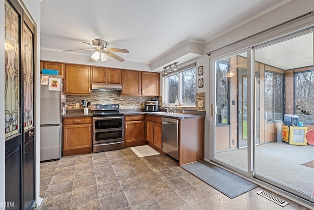 kitchen featuring ceiling fan, sink, stainless steel appliances, tasteful backsplash, and crown molding