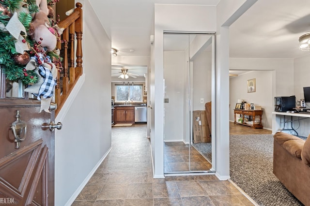 carpeted entrance foyer with ceiling fan and sink