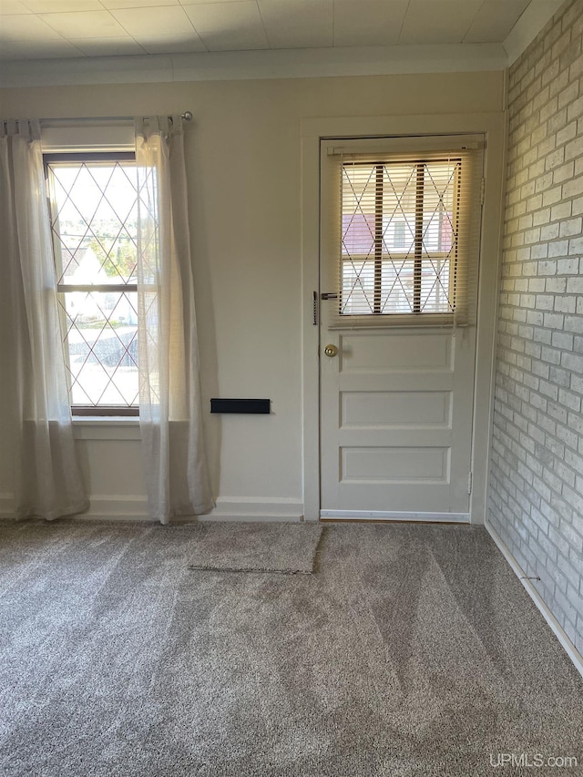 doorway with carpet and brick wall