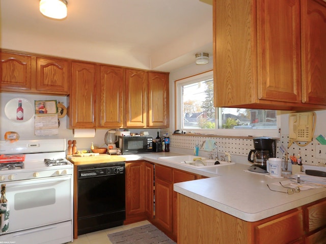 kitchen with decorative backsplash, sink, light tile patterned flooring, and black appliances