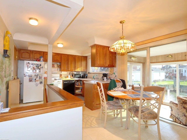 kitchen with black appliances, kitchen peninsula, hanging light fixtures, and a chandelier