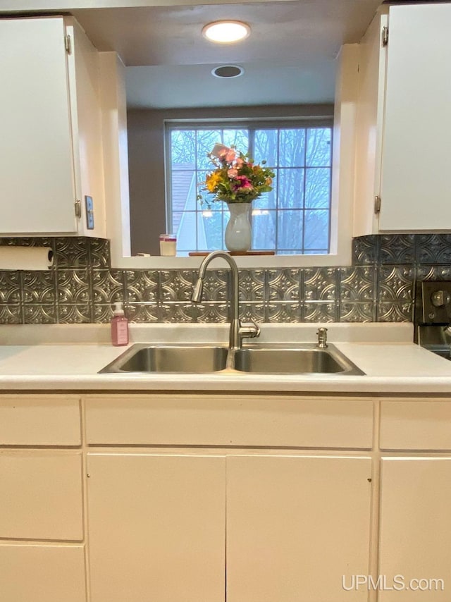 kitchen featuring white cabinets and backsplash