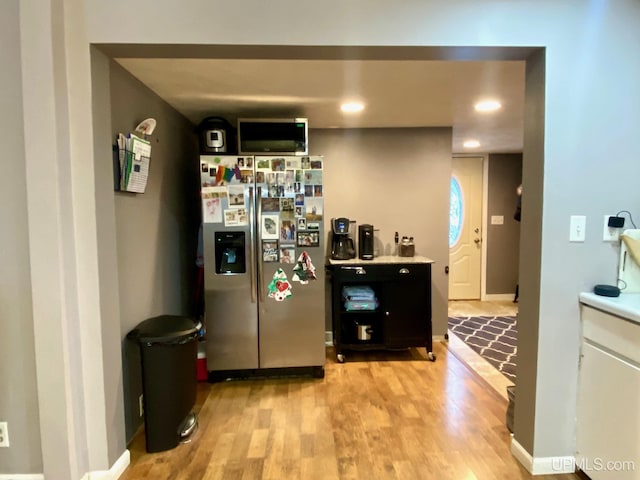 kitchen featuring stainless steel fridge and light hardwood / wood-style floors