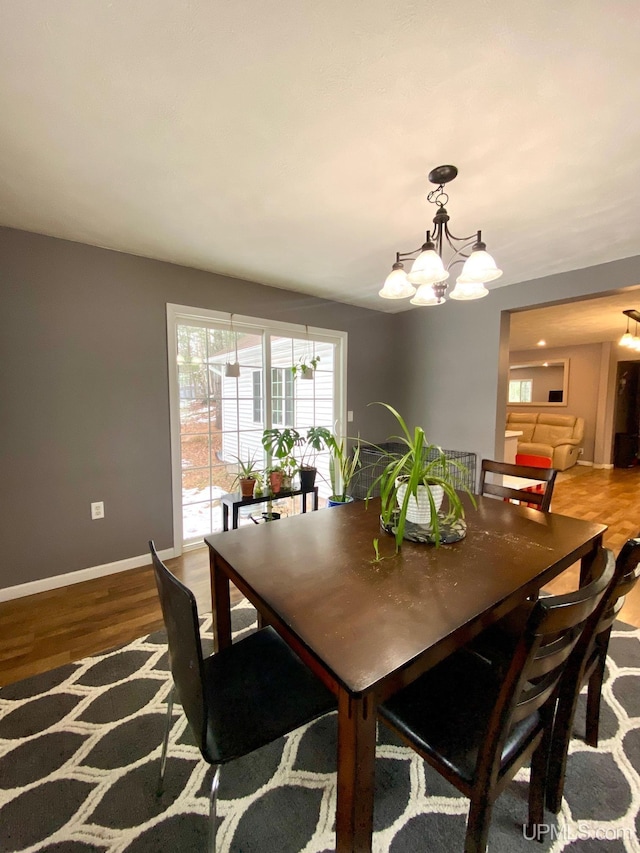 dining area with hardwood / wood-style flooring and a notable chandelier