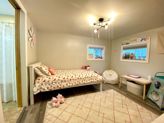 bedroom with an inviting chandelier and hardwood / wood-style flooring