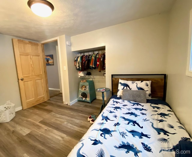 bedroom with wood-type flooring and a closet