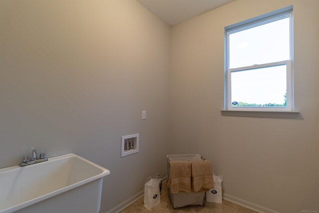 laundry area featuring washer hookup, light tile patterned flooring, and sink