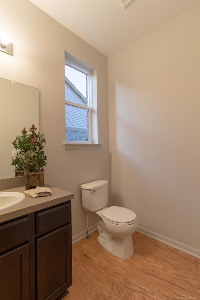 bathroom featuring wood-type flooring, vanity, and toilet