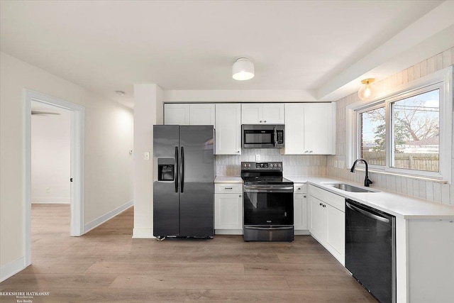 kitchen featuring tasteful backsplash, white cabinetry, sink, and stainless steel appliances