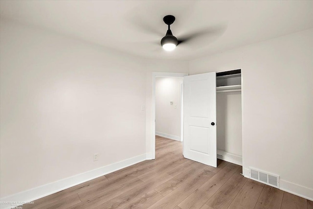 unfurnished bedroom featuring ceiling fan, light hardwood / wood-style flooring, and a closet