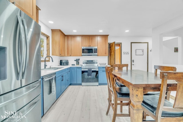 kitchen featuring appliances with stainless steel finishes, light wood-type flooring, and sink