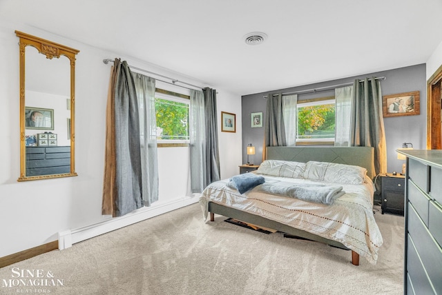 bedroom with light colored carpet and baseboard heating