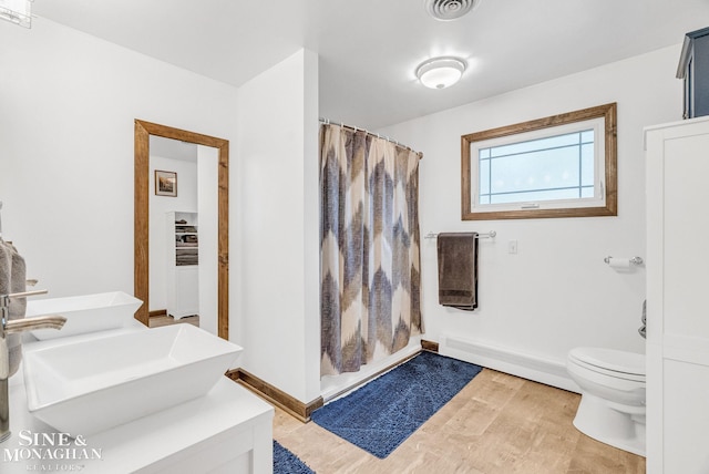 bathroom featuring a shower with curtain, sink, hardwood / wood-style flooring, a baseboard radiator, and toilet