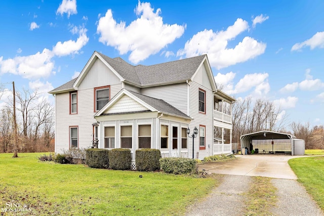 view of front of house featuring a front yard, a balcony, and a carport