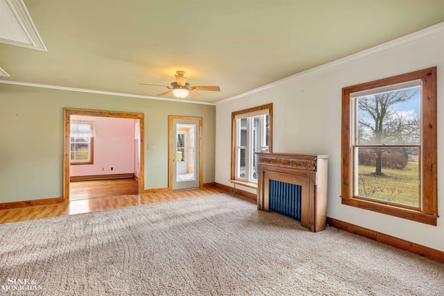 unfurnished living room with ceiling fan, baseboard heating, and crown molding