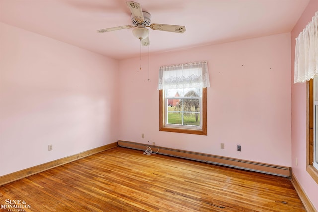 empty room featuring ceiling fan, light hardwood / wood-style floors, and a baseboard heating unit