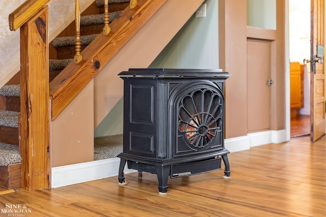 room details with a wood stove and hardwood / wood-style floors