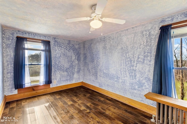 spare room featuring a wealth of natural light, hardwood / wood-style floors, ceiling fan, and a textured ceiling