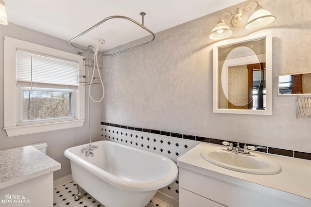 bathroom with tile patterned floors, a tub, and vanity