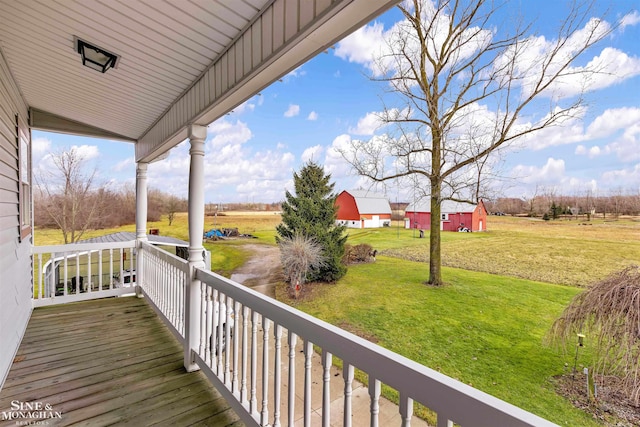 wooden deck with a yard, covered porch, and a rural view