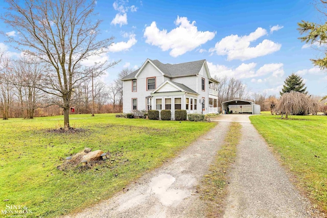 view of property featuring a carport and a front lawn