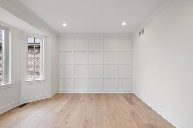 spare room with crown molding and light hardwood / wood-style flooring