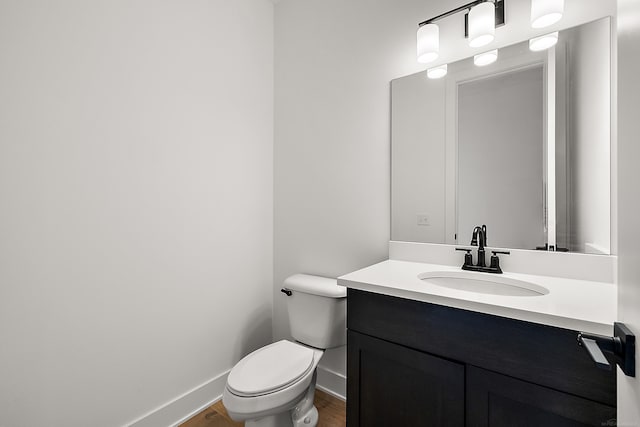 bathroom with vanity, toilet, and hardwood / wood-style floors