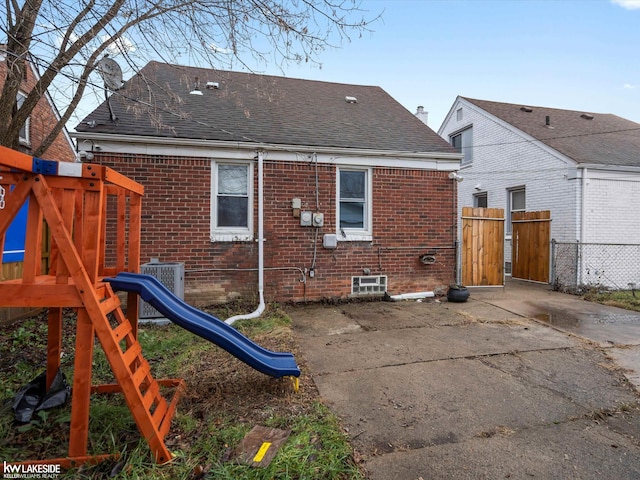 rear view of house with a playground and central AC unit