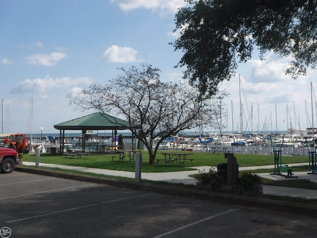 view of parking / parking lot with a gazebo, a yard, and a water view