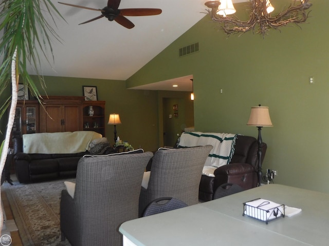 living room with ceiling fan with notable chandelier and vaulted ceiling