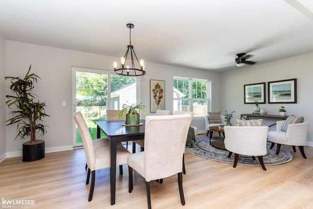 dining area with ceiling fan with notable chandelier and light hardwood / wood-style floors