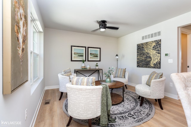 sitting room with ceiling fan and light wood-type flooring