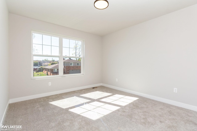 spare room featuring light carpet