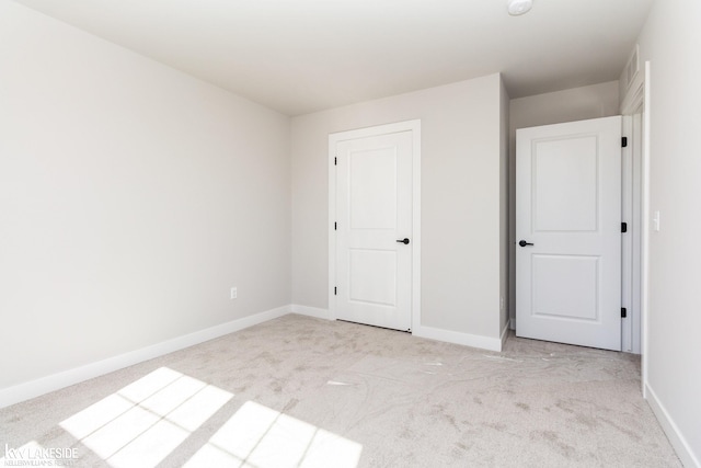 unfurnished bedroom featuring light carpet