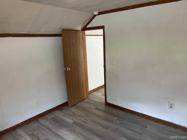 additional living space with light hardwood / wood-style floors and lofted ceiling