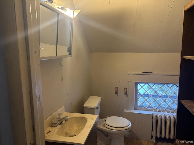 bathroom featuring lofted ceiling, toilet, radiator heating unit, and vanity