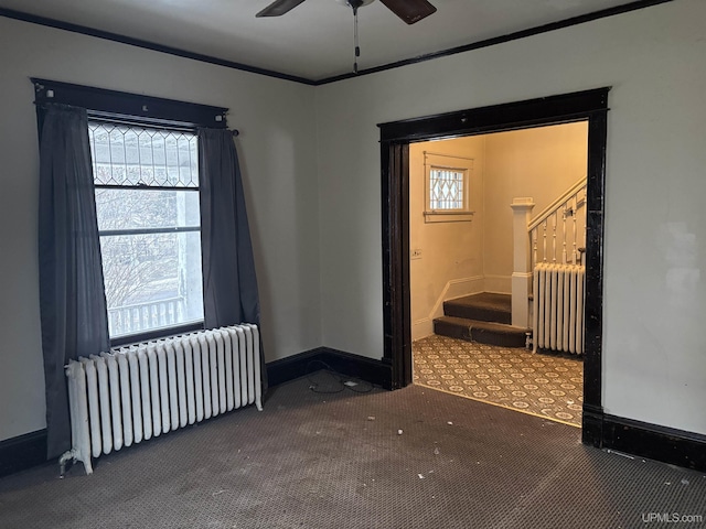 carpeted empty room featuring radiator heating unit, ceiling fan, and ornamental molding