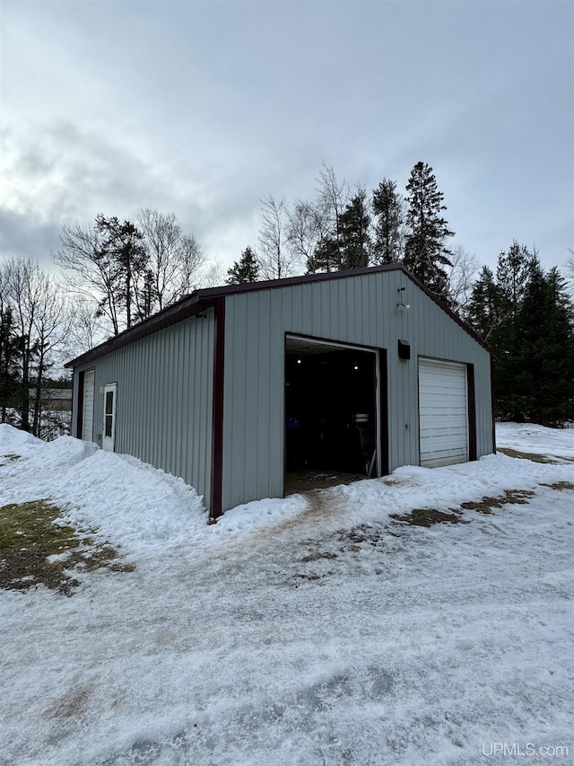 snow covered structure with a garage