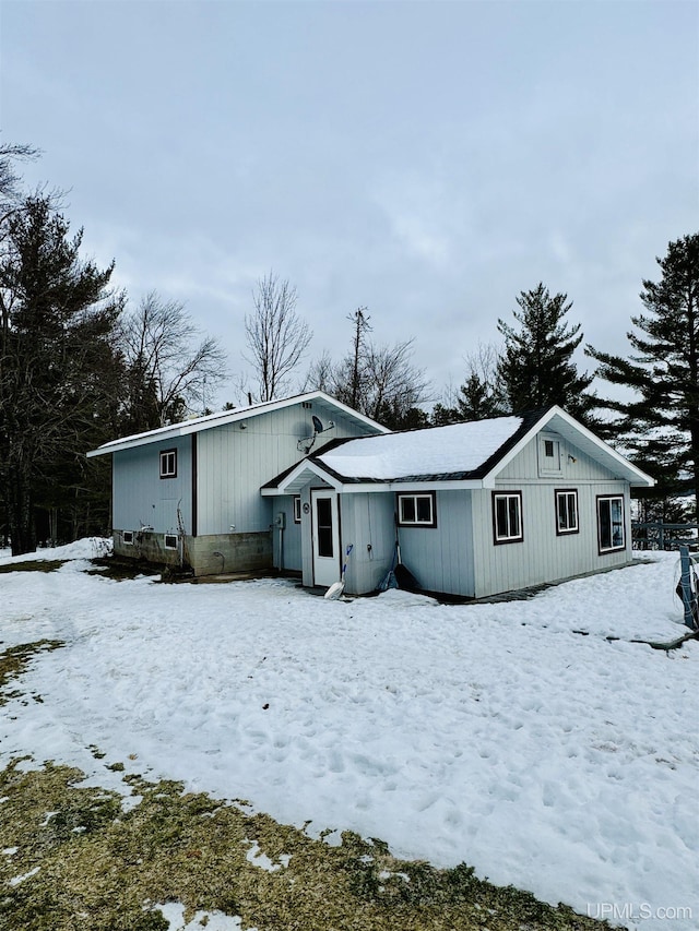 view of snow covered back of property