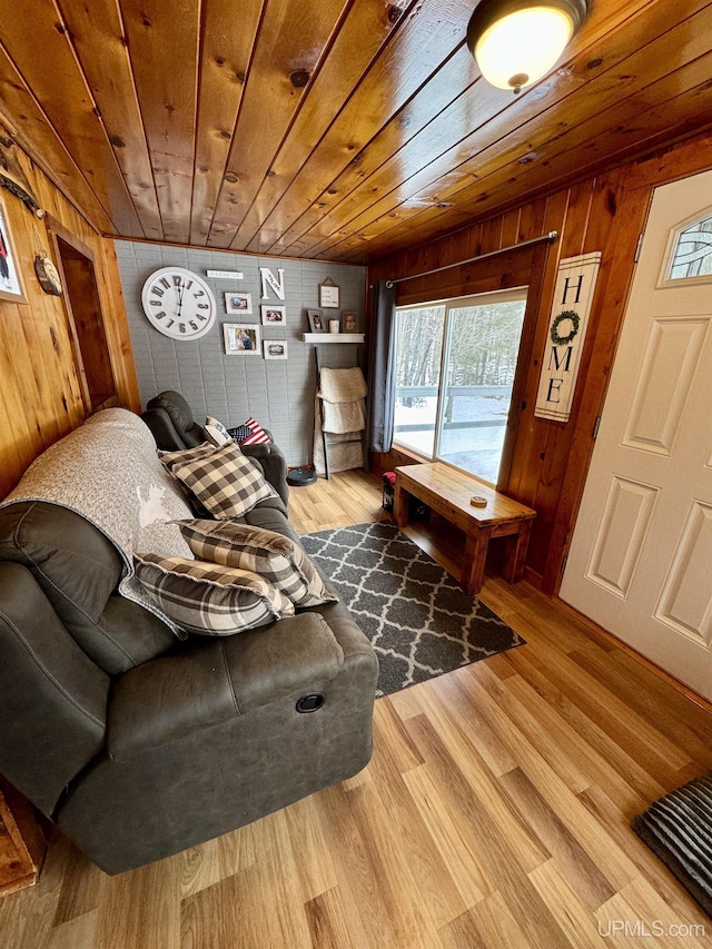 living room with light wood-type flooring, wooden walls, and wooden ceiling