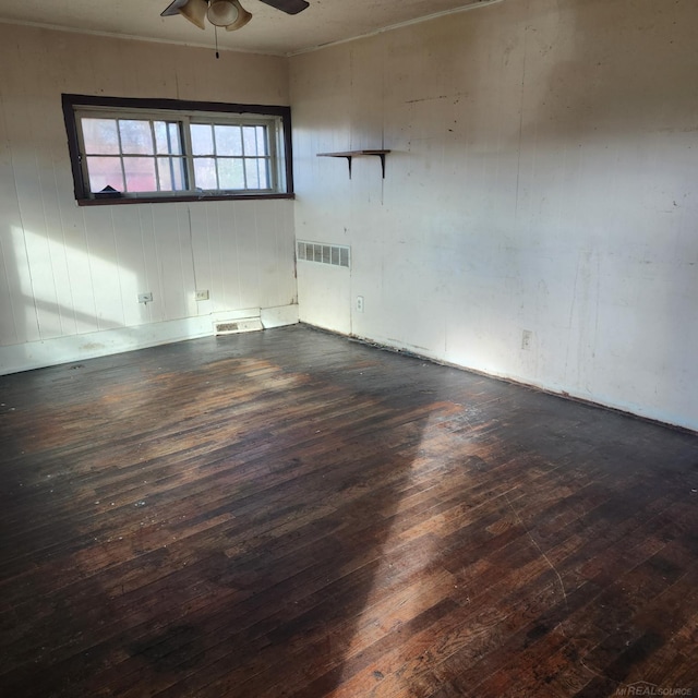 spare room with dark hardwood / wood-style flooring and ceiling fan