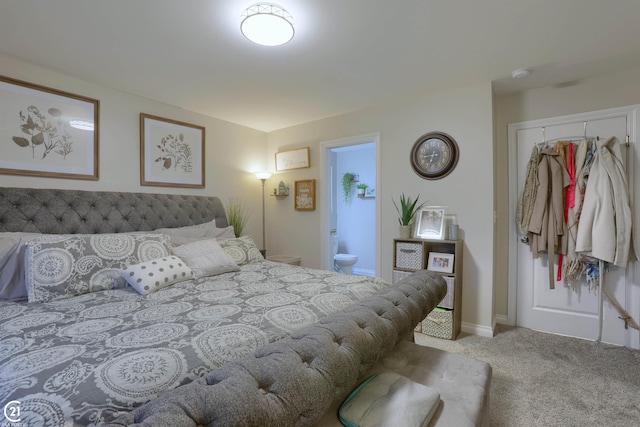 carpeted bedroom featuring a closet and ensuite bath