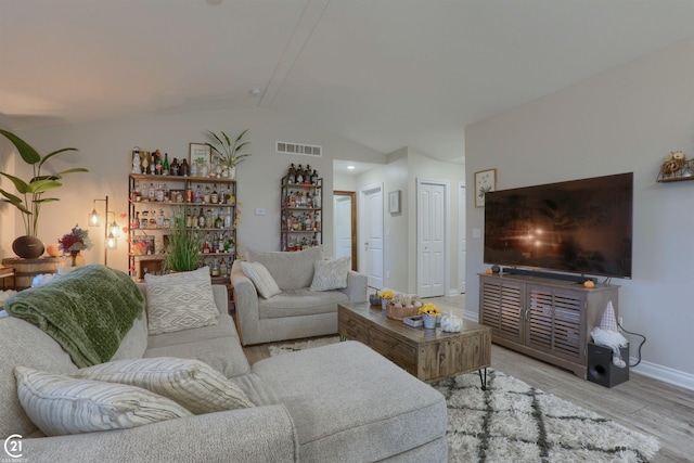 living room featuring light hardwood / wood-style floors and vaulted ceiling