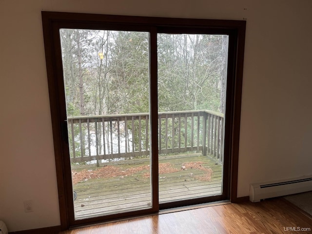 doorway to outside with light hardwood / wood-style floors, a baseboard heating unit, and a water view